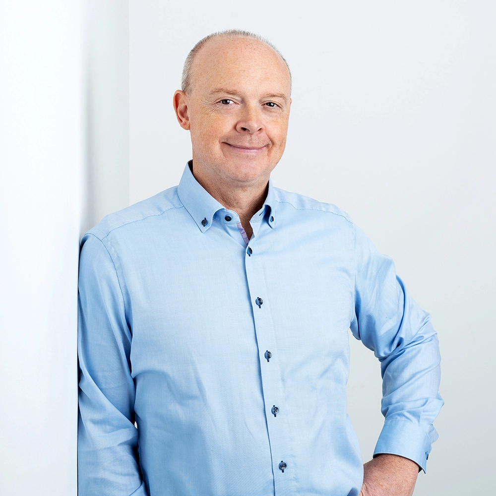 Sophie-mare-Photographe-seingbouse-portrait-corporate-professionel-profil-cv-linkedin-site-internet-02 homme souriant en chemise bleue contre un mur blanc