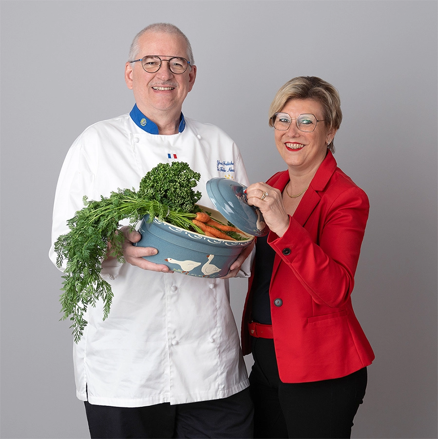 Sophie-mare-Photographe-seingbouse-portrait-corporate-professionel-profil-cv-linkedin-site-internet-09 couple de restaurateurs avec une terrine en porcelaine pleine de carottes et persil, femme en veste rouge, homme en tenue de cuisinier blanche