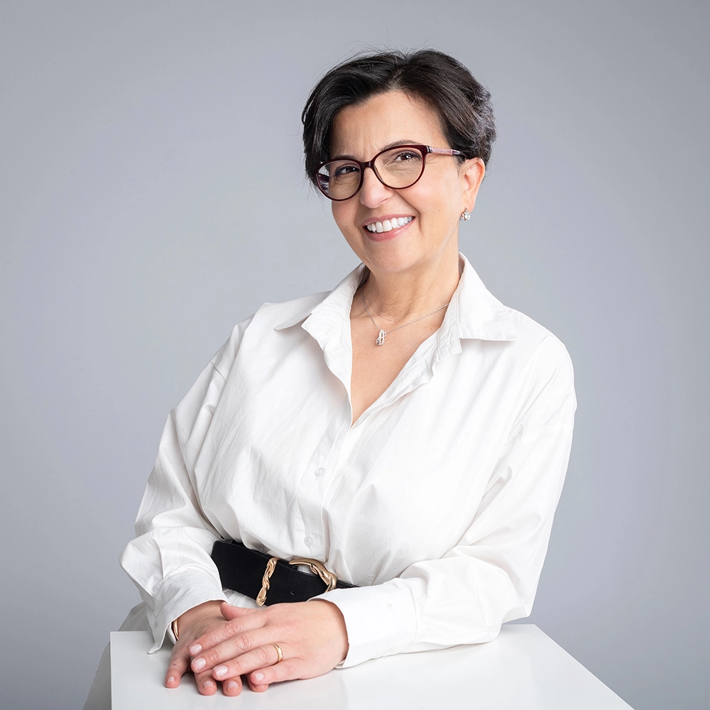 Sophie-mare-Photographe-seingbouse-portrait-corporate-professionel-profil-cv-linkedin-site-internet-18 une femme en chemise grise et lunettes, souriante, sur fond gris