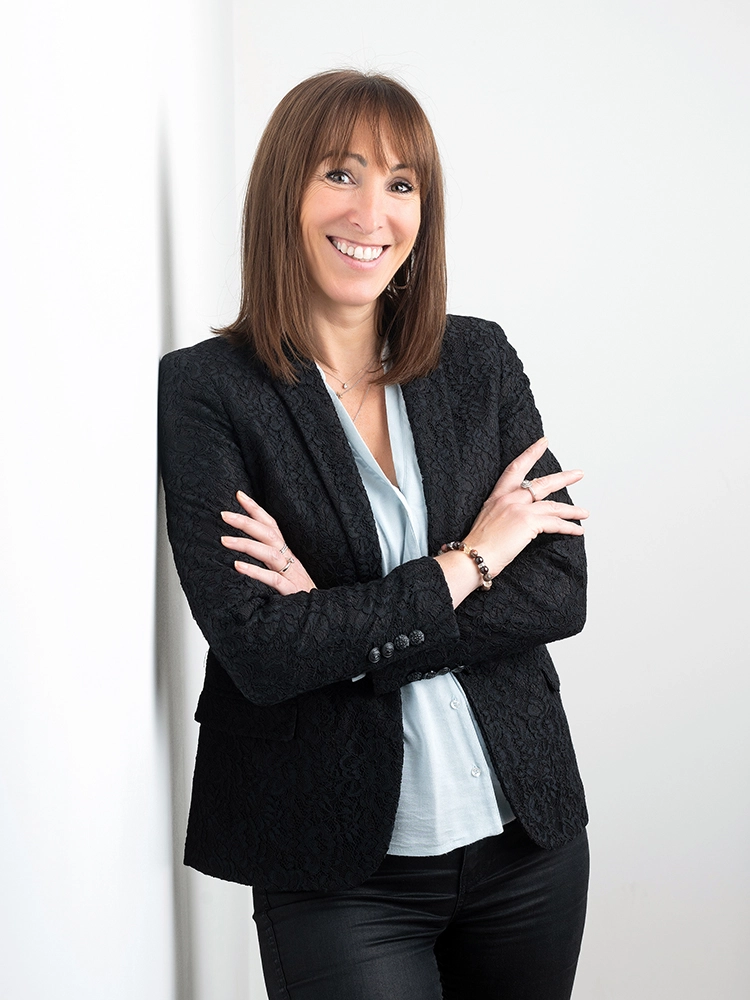 Sophie-mare-Photographe-seingbouse-portrait-corporate-professionel-profil-cv-linkedin-site-internet-29 femme souriante en tailleur noir, contre un mur, bras croisés