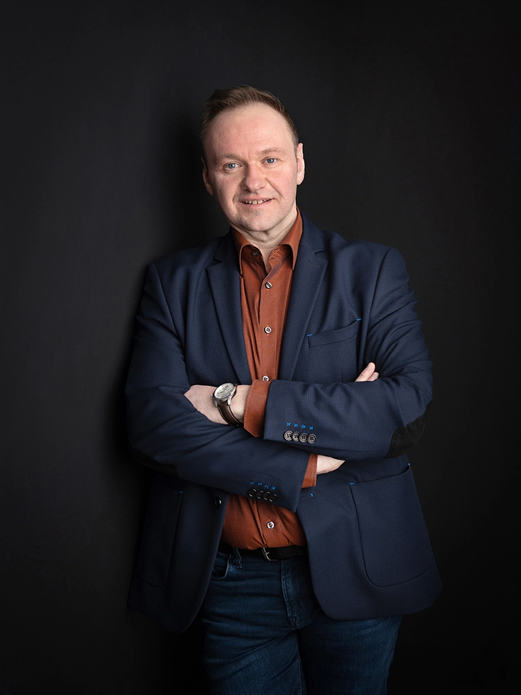 Sophie-mare-Photographe-seingbouse-portrait-corporate-professionel-profil-cv-linkedin-site-internet-32 homme en chemise orange et veste de costume bleue, contre un mur noir