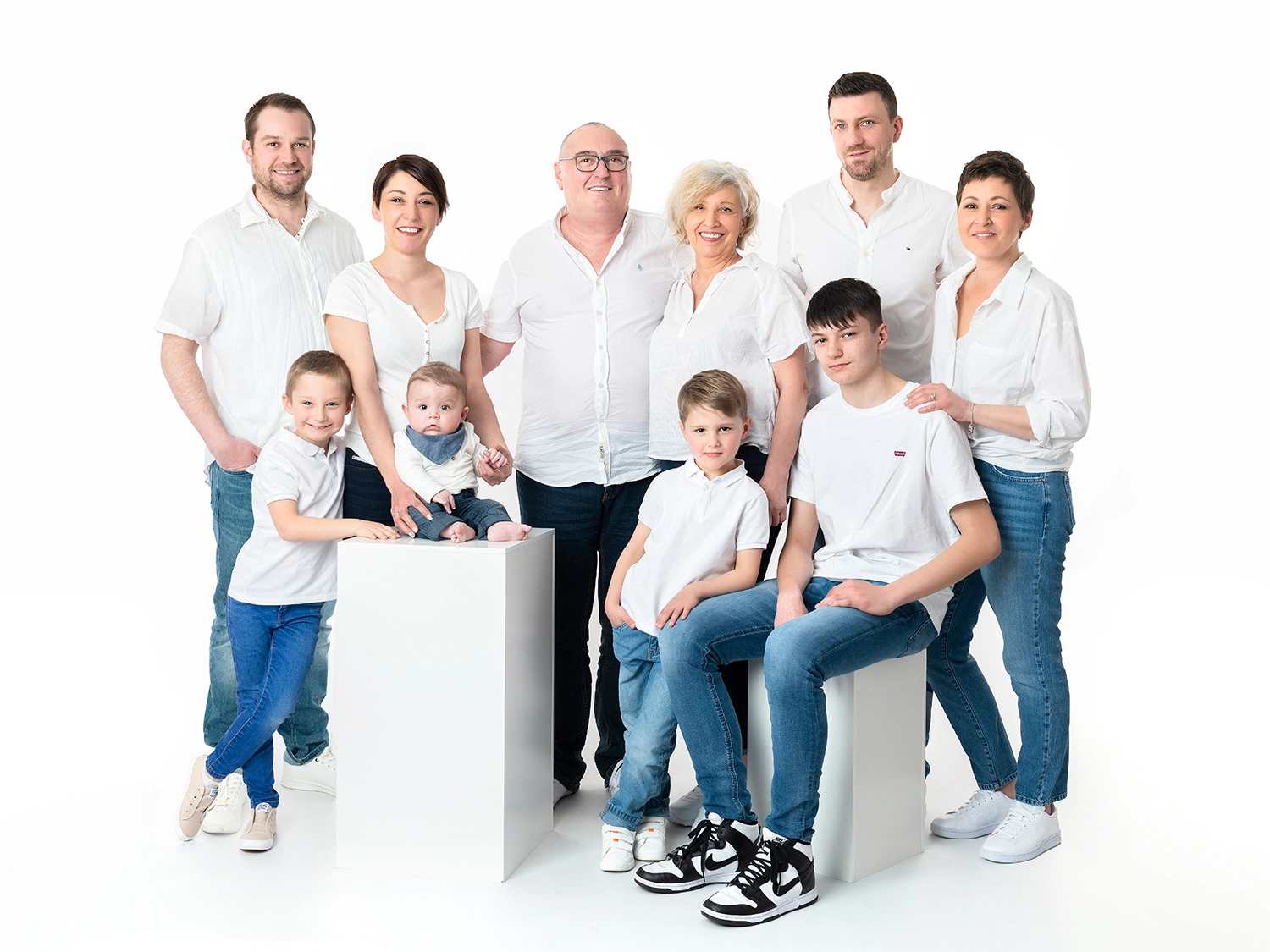 une grande famille en jean et haut blanc sur fond blanc.