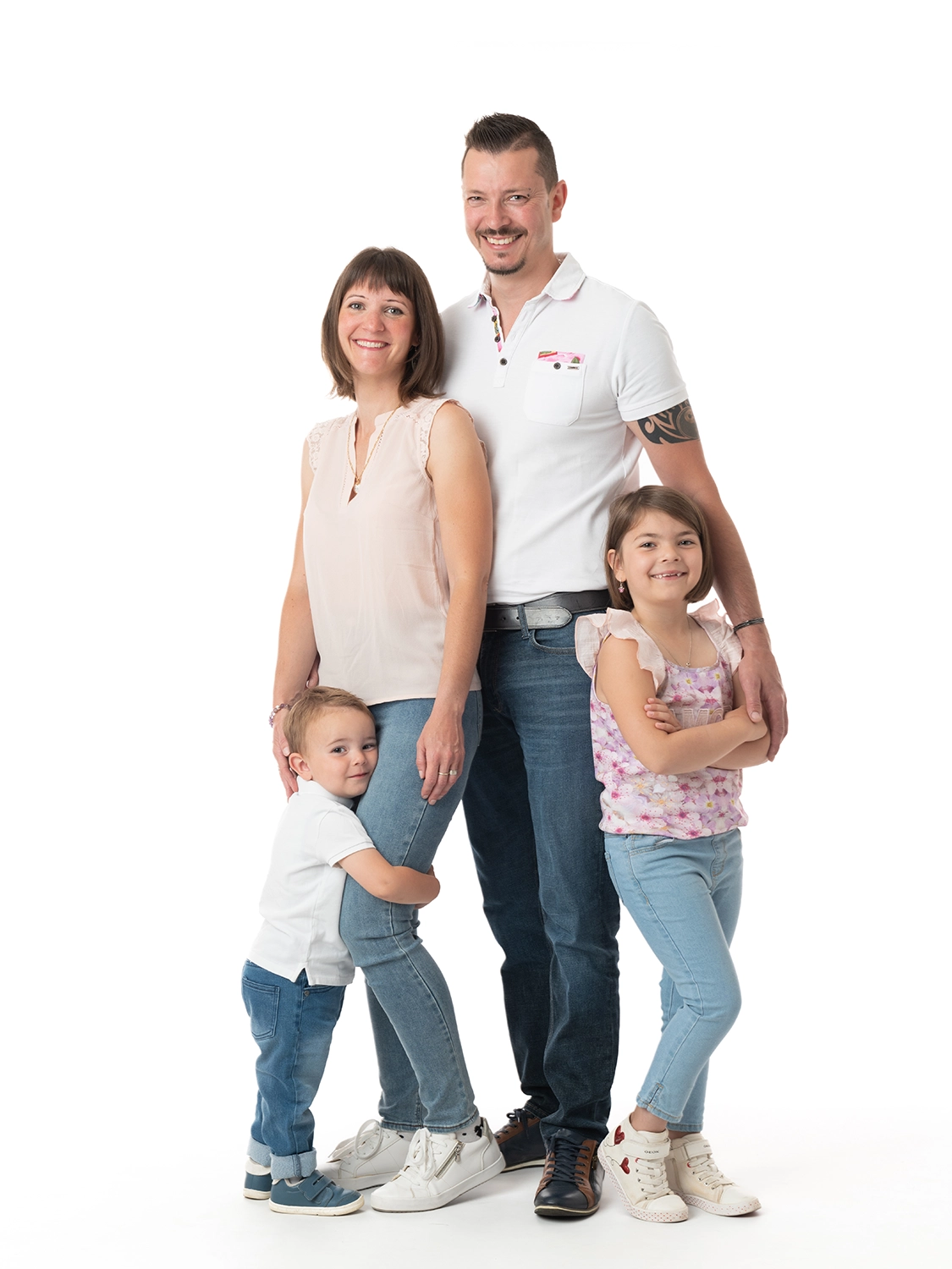 une famille de 4 personnes en jean sur fond blanc avec un petit garçon et une petite fille