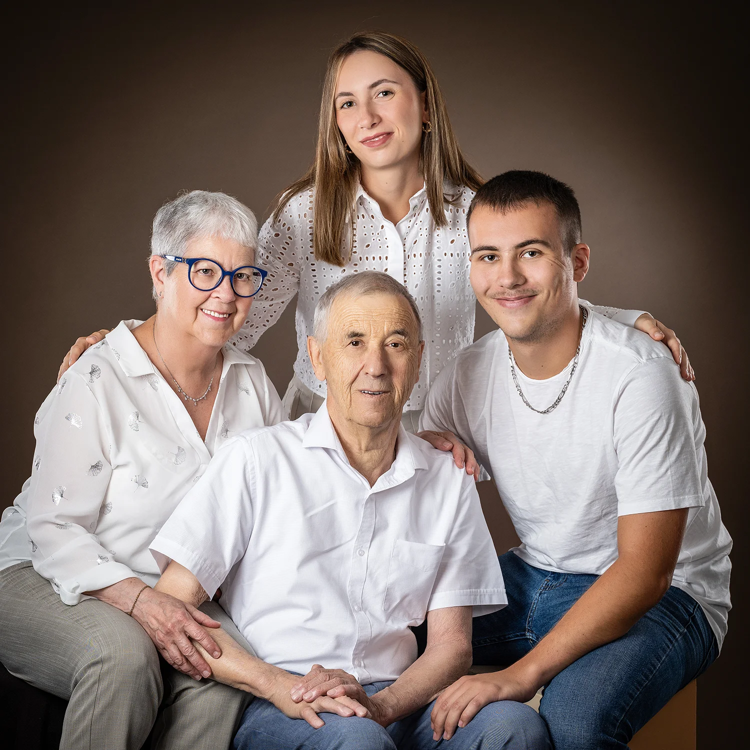grands-parents et petits enfants en tenue blanche sur fond marron