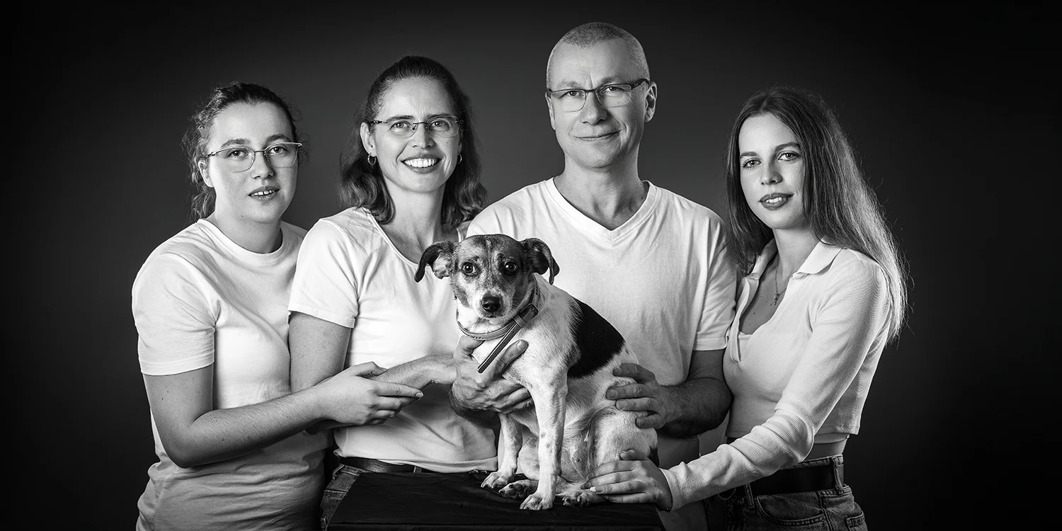 une famille de 4 personnes et un chien au centre en t shirt blanc sur fond noir