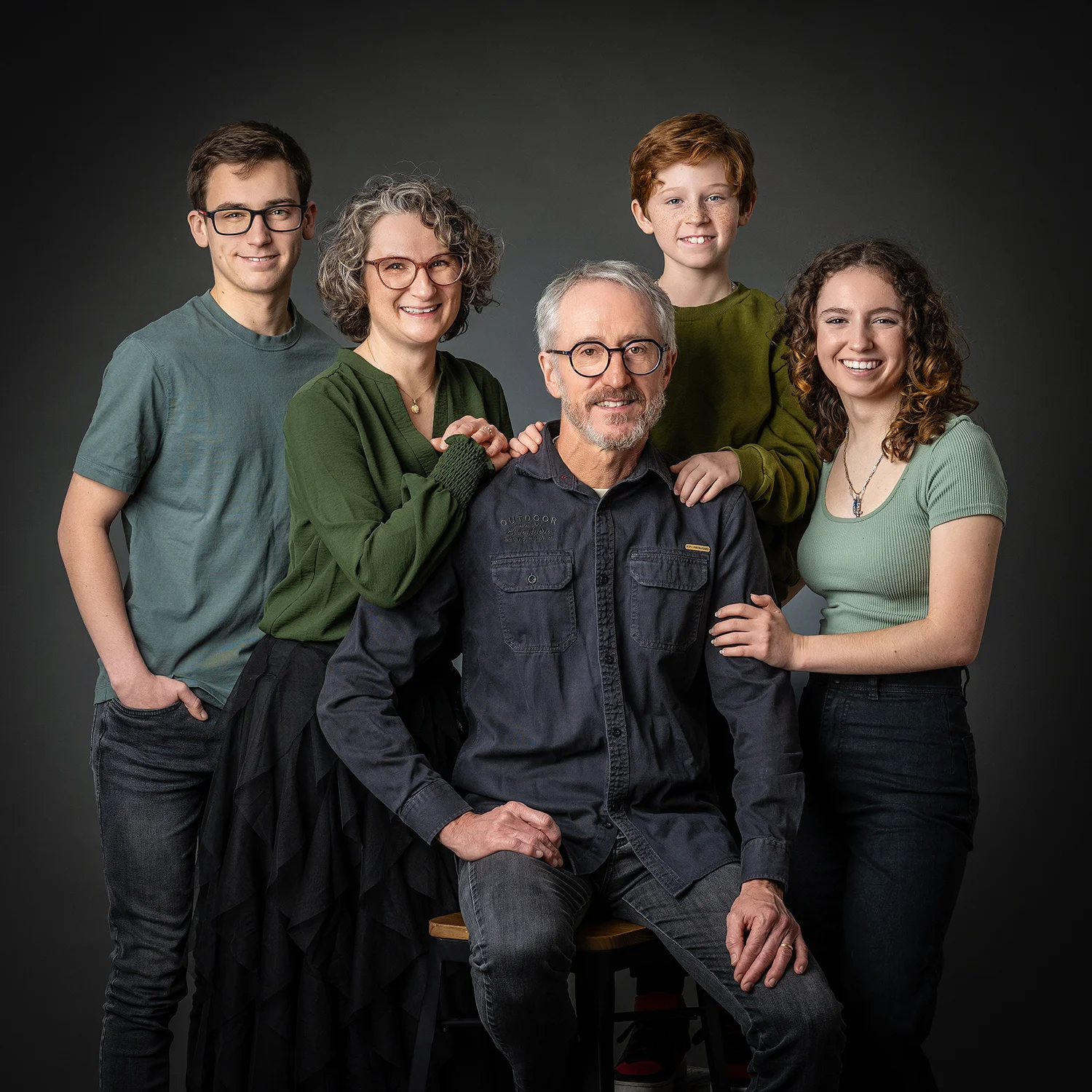 une famille de 5 personnes dans des teintes kaki sur fond noir avec un petit garçon roux