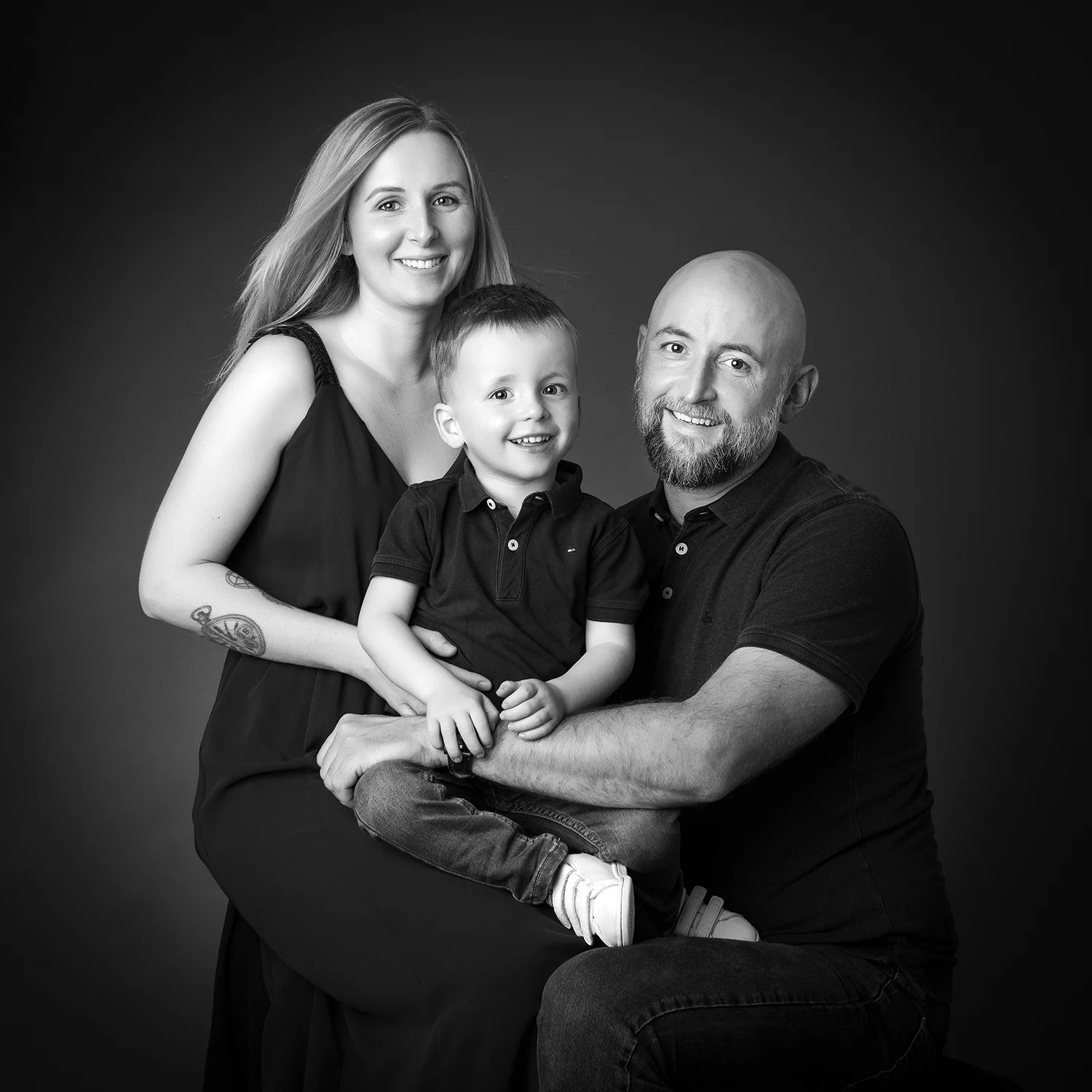 papa maman et petit garçon sur fond noir en tenue noire