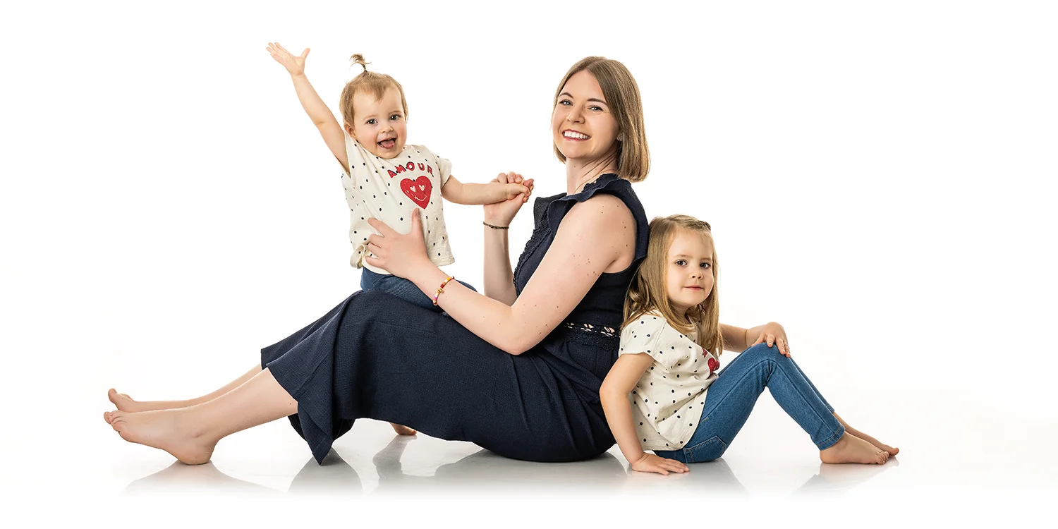 maman en combinaison bleue et 2 petites filles au sol sur fond blanc