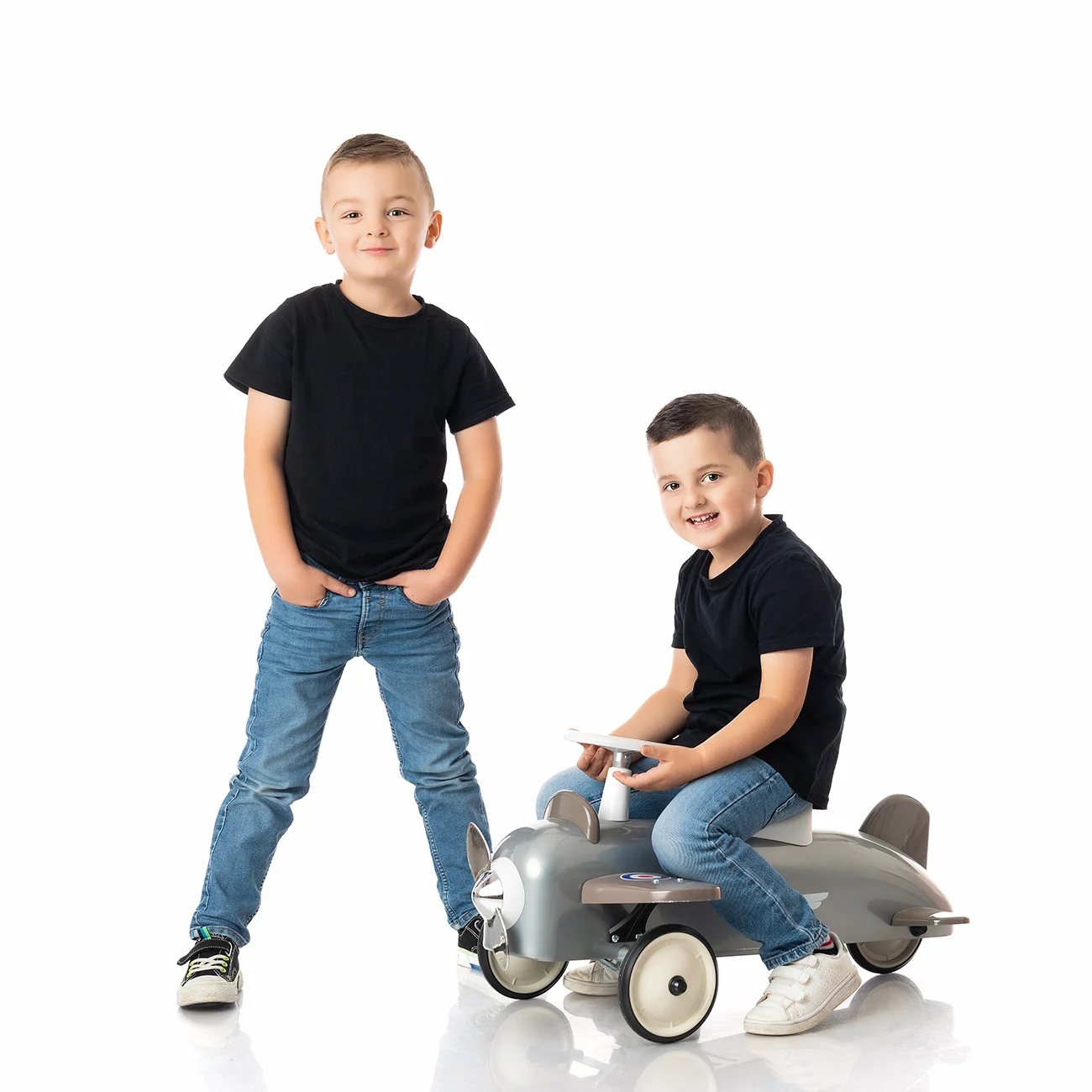 studio-seingbouse-photographe-sophie-julien-mare-fratrie-enfant-parents-frere-soeur-portrait-04 2 frères garçons en t shirt noir et jean, avec un jouet avion sur fond blanc