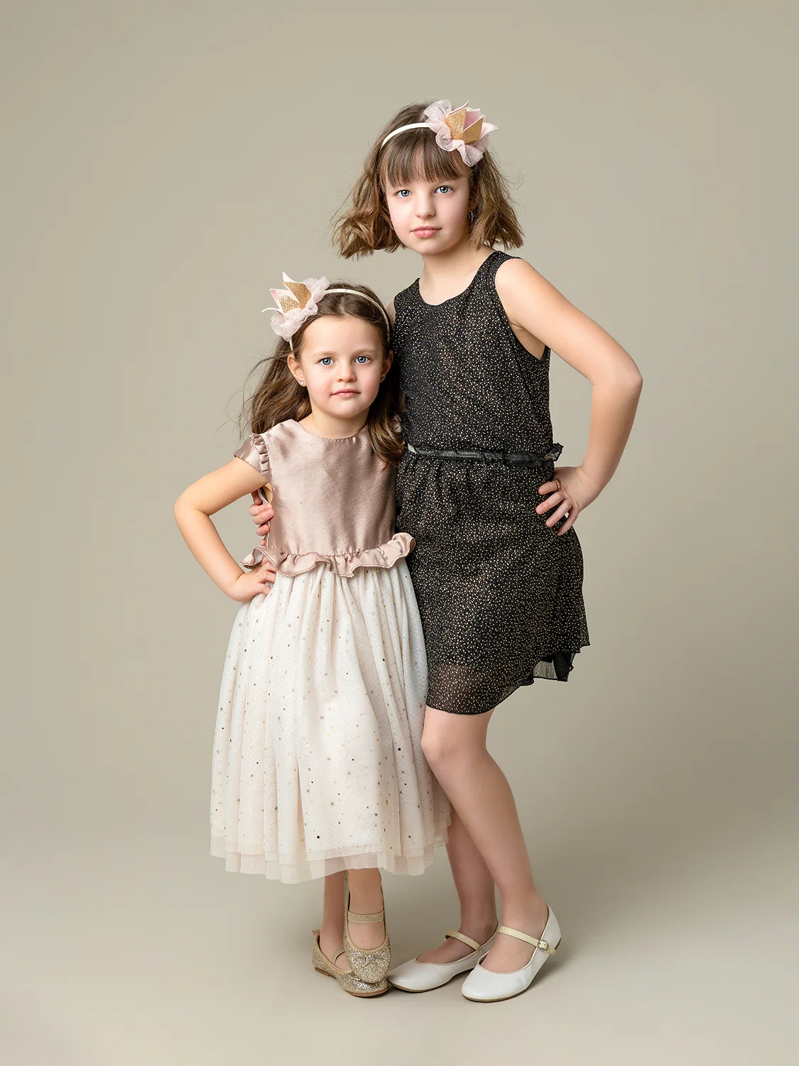 studio-seingbouse-photographe-sophie-julien-mare-fratrie-enfant-parents-frere-soeur-portrait-12 2 soeurs en tenues élégantes et ballerines sur fond beige naturel