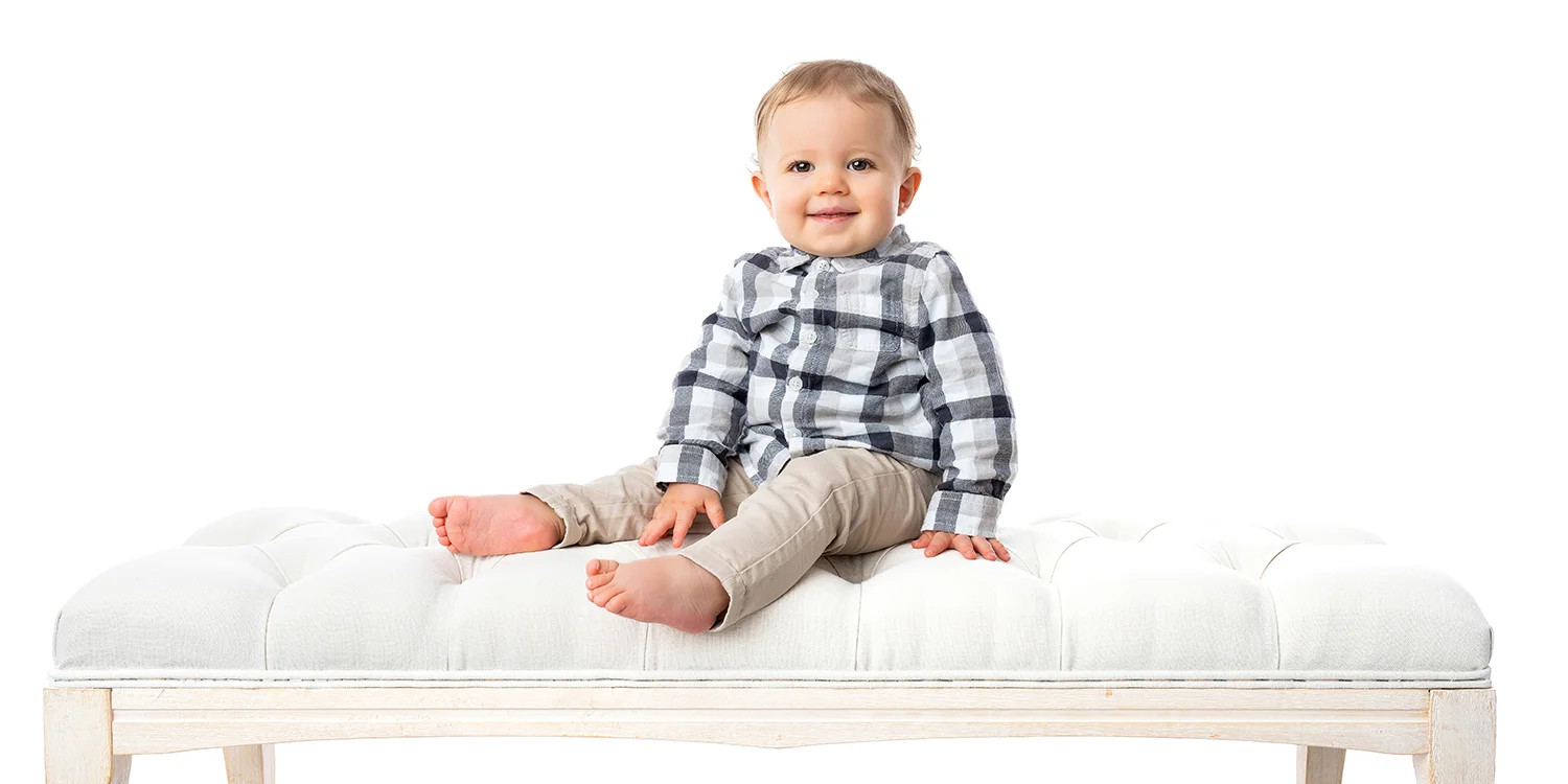 studio-seingbouse-photographe-sophie-julien-mare-fratrie-enfant-parents-frere-soeur-portrait-16 garçon en chemise à carreaux assis sur un banc, fond blanc