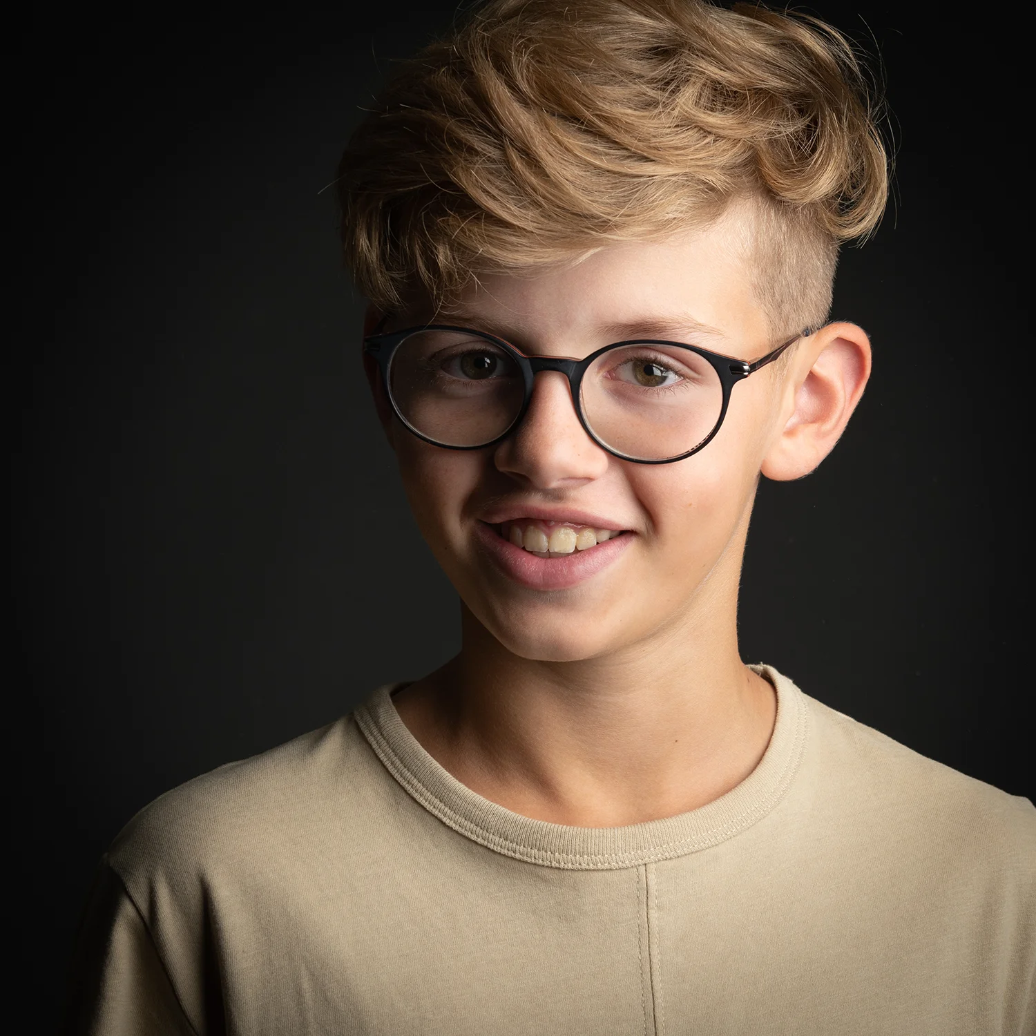 studio-seingbouse-photographe-sophie-julien-mare-fratrie-enfant-parents-frere-soeur-portrait-52 garçon blond à lunettes sur fond noir et t shirt beige