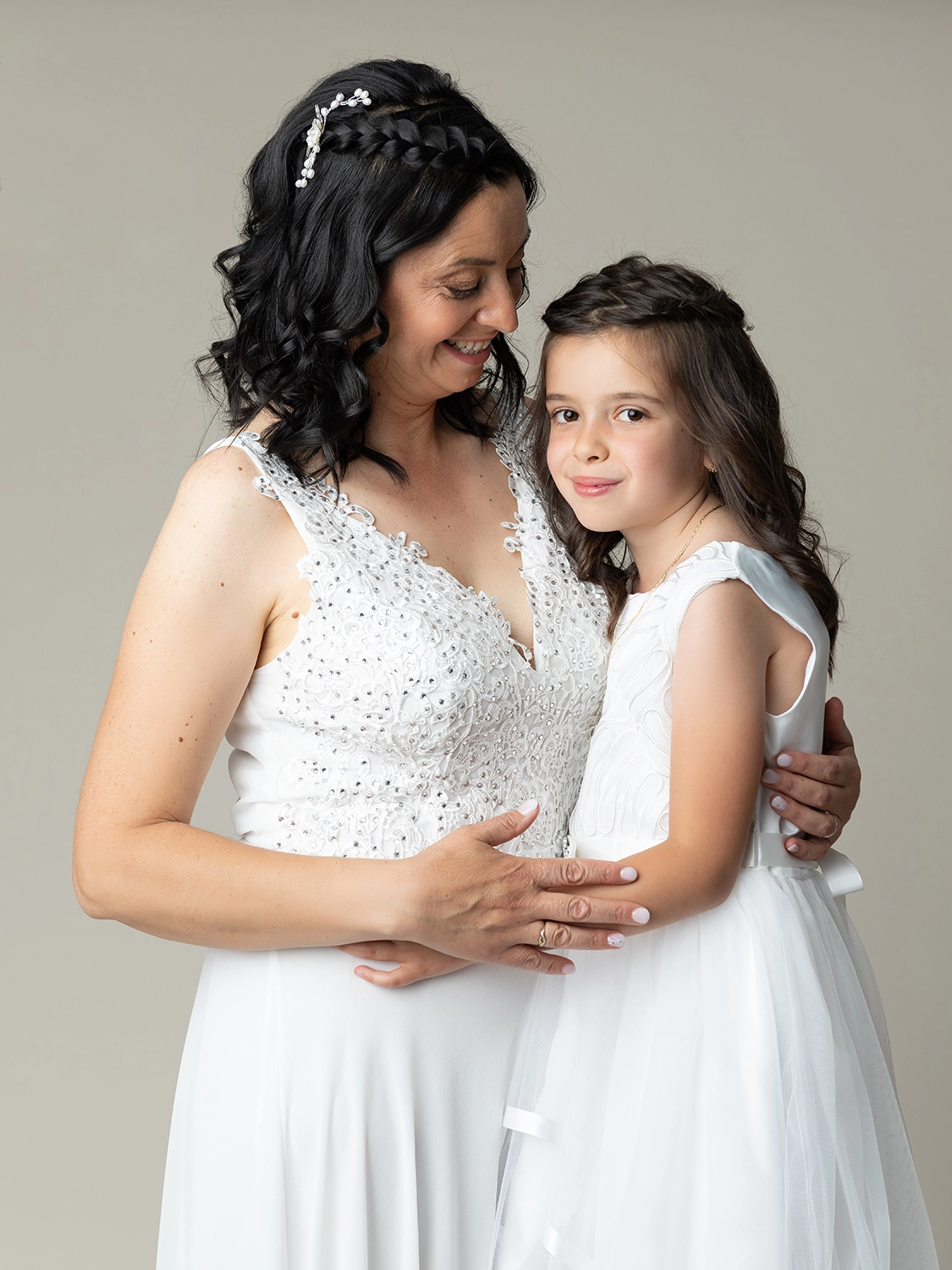 studio-sophie-mare-mariage-photos-seingbouse-merlebach-portrait-06 une petite fille en robe blanche et sa maman et robe de mariée sur fond beige naturel