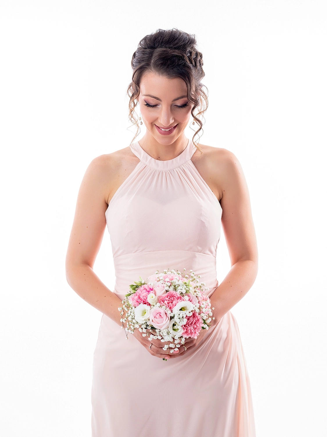 studio-sophie-mare-mariage-photos-seingbouse-merlebach-portrait-14 une mariée souriante, de face, qui regarde son bouquet qu'elle tient devant elle avec ses deux mains.