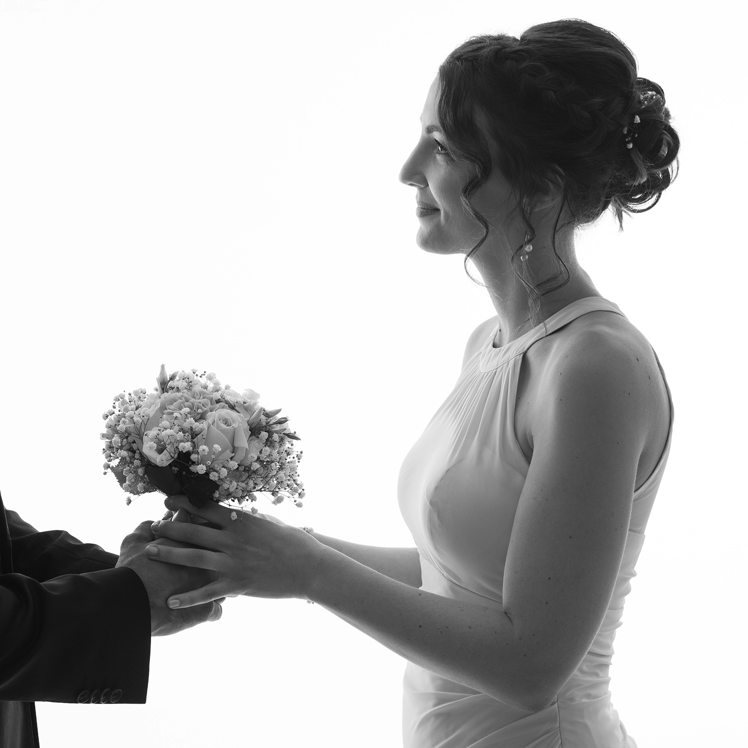 studio-sophie-mare-mariage-photos-seingbouse-merlebach-portrait-16 une mariée sur fond blanc qui reçoit un bouquet des mains de son futur mari