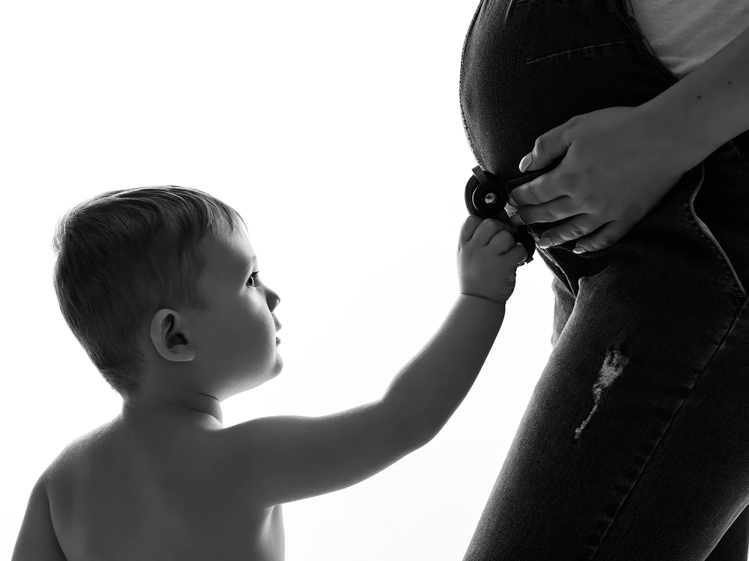 studio-seingbouse-photographe-sophie-julien-mare-grossesse-enceinte-parents-bebe-naissance-shooting-02 petit garçon qui fait rouler une voiture sur le ventre de sa maman enceinte, fond blanc