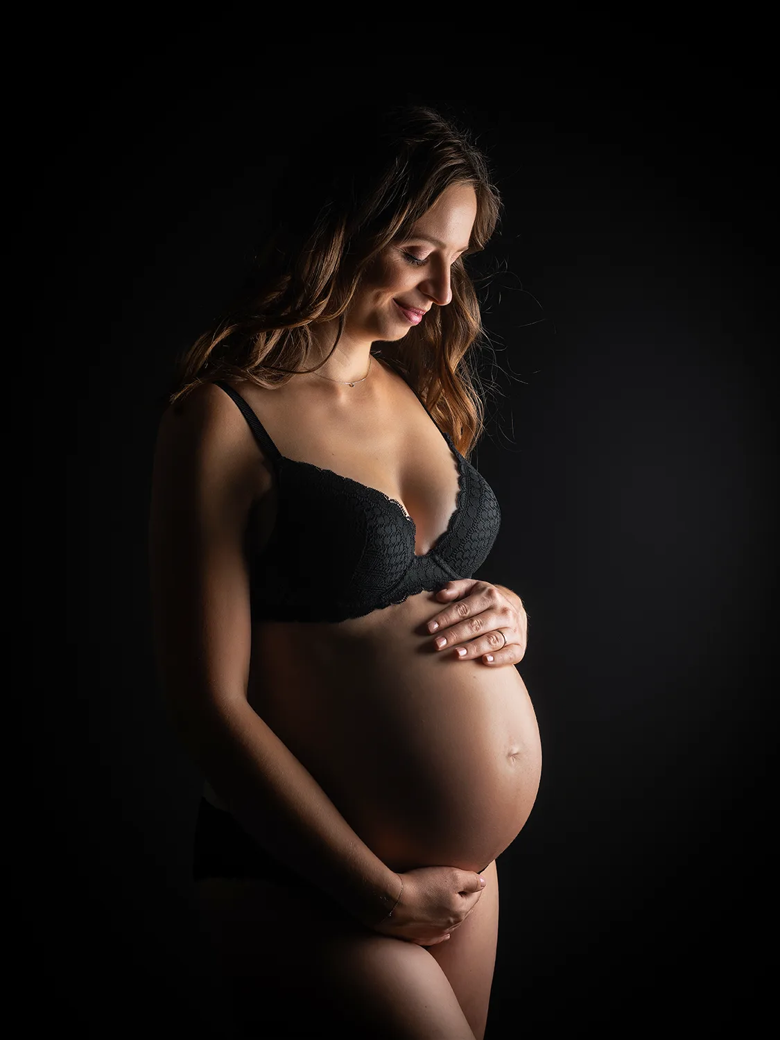 studio-seingbouse-photographe-sophie-julien-mare-grossesse-enceinte-parents-bebe-naissance-shooting-13 femme enceinte souriante en sous-vêtements noirs sur fond noir